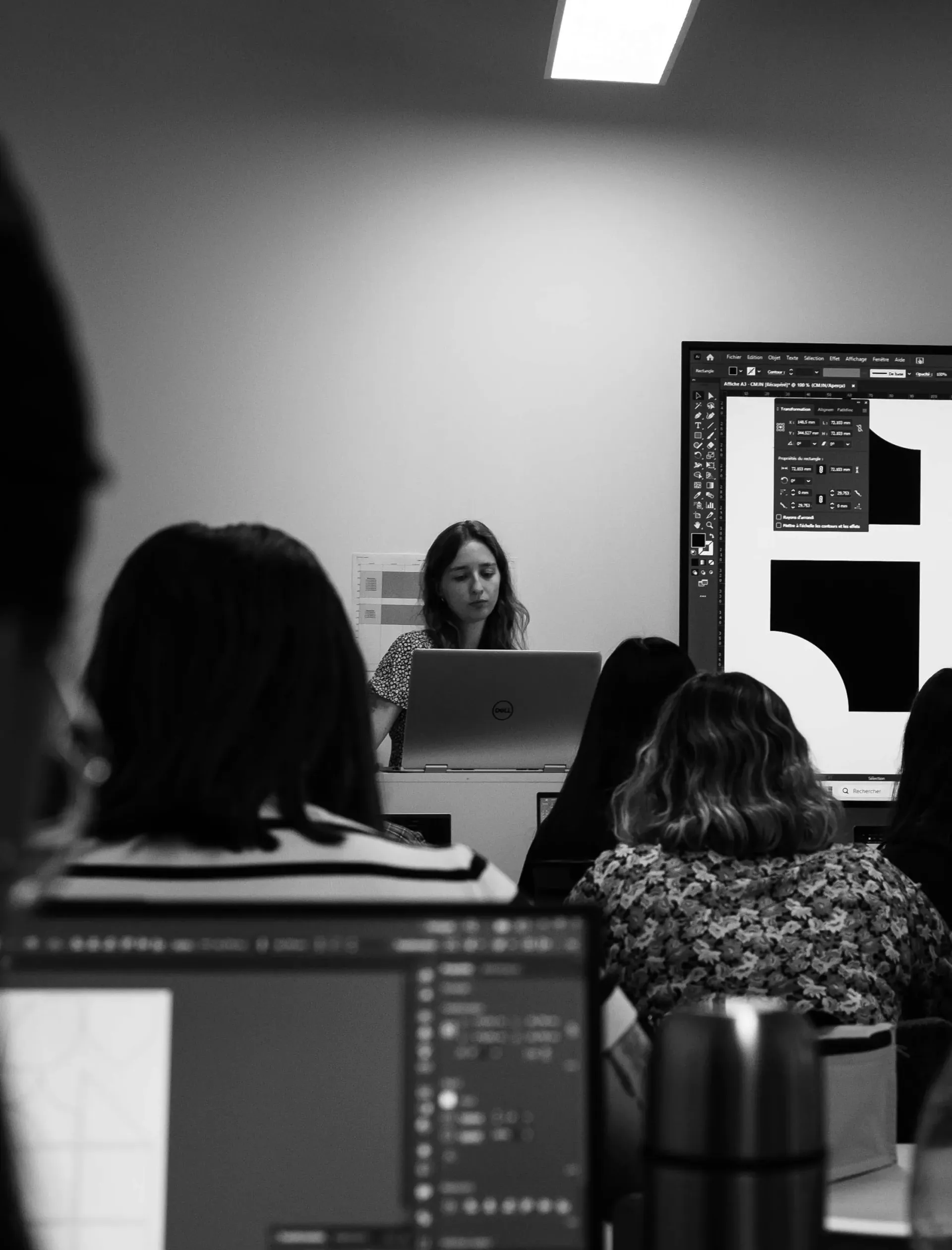 Camille Zwick, designer graphique, accompagnant des étudiants dans l'apprentissage des logiciels de la suite Adobe.